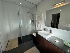 ein Bad mit einem Waschbecken und einer Dusche in der Unterkunft Pinheiros House by ALPONTE in Monção