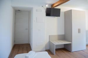 um quarto branco com um banco e um armário em Albergo Panorama em Malesco
