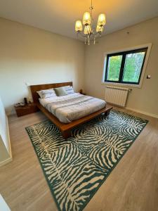 ein Schlafzimmer mit einem Bett und einem Zebra-Teppich in der Unterkunft Pinheiros House by ALPONTE in Monção