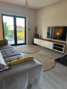 ein Wohnzimmer mit einem Sofa und einem Flachbild-TV in der Unterkunft Pinheiros House by ALPONTE in Monção