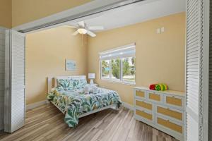 a bedroom with a bed and a window at Renovated Cottage at the Historic Palms Inn of Sanibel- Includes Pool and Bikes in Sanibel