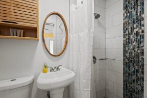 a white bathroom with a sink and a mirror at Renovated Cottage at the Historic Palms Inn of Sanibel- Includes Pool and Bikes in Sanibel