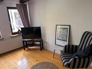 uma sala de estar com uma televisão e duas cadeiras e uma mesa em Traumschönes Fachwerk in Hamelns Altstadt em Hameln