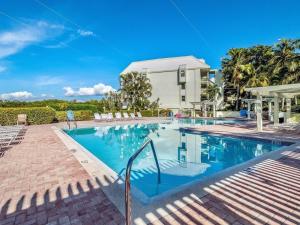 a swimming pool with chairs and a building at Family-Friendly Bayside Villa at South Seas Resort in Captiva