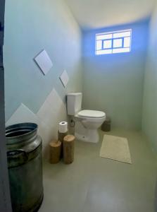 a white bathroom with a toilet and a window at Casa Vita BG - Casa de campo in Bento Gonçalves