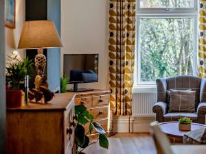 a living room with a tv and a chair and a table at 2 Bed in Totnes 94724 in Totnes