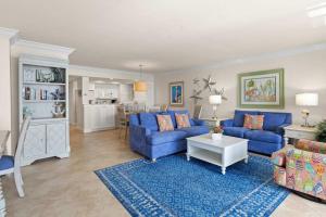 a living room with blue couches and a kitchen at Gorgeous Renovated Residence in Upscale Sanibel Harbour Tower in Fort Myers