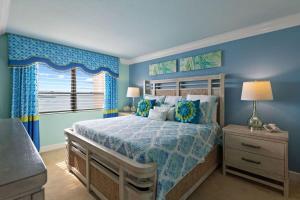 um quarto azul com uma cama e uma janela em Gorgeous Renovated Residence in Upscale Sanibel Harbour Tower em Fort Myers