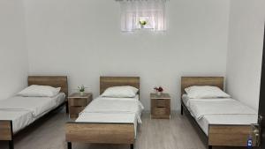 a room with three beds and a window at Hostel,halal in Tokmok