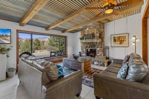 a living room with two leather couches and a fireplace at Mid-century Ranch Home in Sedona with Fantastic Red Rock Views in Sedona