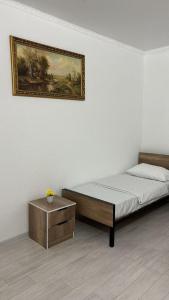 a bedroom with a bed and a painting on the wall at Hostel,halal in Tokmok