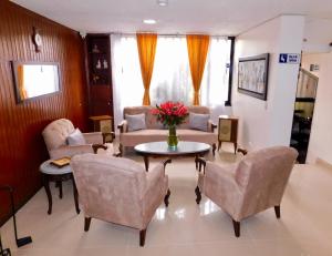 uma sala de estar com sofás, uma mesa e cadeiras em Hotel Casa Navi em Bogotá