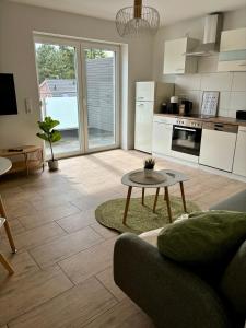 a living room with a table and a kitchen at Home & Apart - Apartment im Herzen von Kreyenbrück - Apartment 1 in Oldenburg