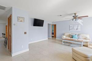 a living room with a couch and a ceiling fan at Cute Coastal Home with Pool in Fort Myers