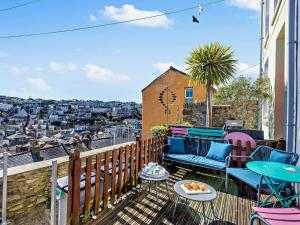 a balcony with chairs and tables and a view of a city at 3 bed in Brixham BX038 in Brixham