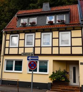 une maison jaune et noire avec un panneau devant elle dans l'établissement Stadt-Ferienwohnung mit 55 m² für 2 erw. Personen und Kind bis 3 Jahren, à Bad Lauterberg