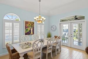 a dining room with a white table and chairs at 144 Mango St in Fort Myers Beach