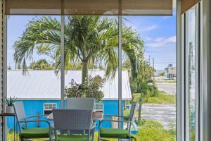 a patio with chairs and a table and a palm tree at 144 Mango St in Fort Myers Beach +10 photos