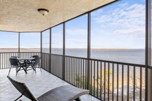 uma varanda com uma mesa e cadeiras e o oceano em Stunning Waterfront Residence with Panoramic Water Views em Fort Myers