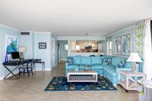 a living room with a blue couch and a table at Stunning Waterfront Residence with Panoramic Water Views in Fort Myers