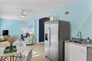 a kitchen with a stainless steel refrigerator and a dining room at Gorgeous Apartment on Mango St Steps to Beach in Fort Myers Beach