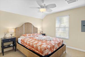 a bedroom with a large bed with a ceiling fan at Gorgeous Apartment on Mango St Steps to Beach in Fort Myers Beach