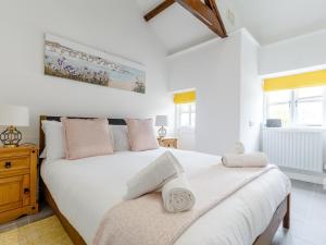 2 Bed in Falmouth 78621 في بينرين: غرفة نوم بسريرين مع شراشف بيضاء ومخدات وردية