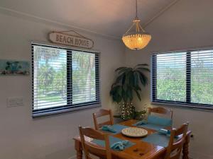 a dining room with a table and chairs and a chandelier at Gorgeous 3 Bedroom Home in the Dunes Sleeps 8 in Sanibel