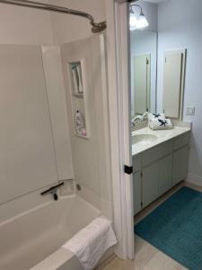 a bathroom with a tub and a sink and a mirror at Gorgeous 3 Bedroom Home in the Dunes Sleeps 8 in Sanibel