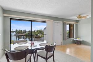 a dining room with a glass table and chairs at Comfy Waterfront Condo at Tennisplace Sanibel in Sanibel