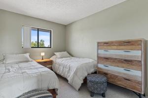 a bedroom with two twin beds and a dresser at Comfy Waterfront Condo at Tennisplace Sanibel in Sanibel