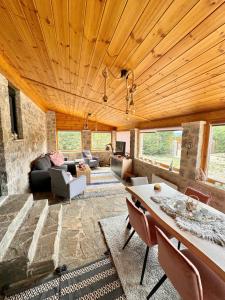 a living room with a wooden ceiling and a table at Crown Luxurious Residence in Arachova