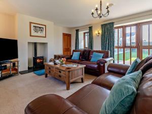 a living room with leather furniture and a fireplace at 2 Bed in Helston ROSEB in Wendron