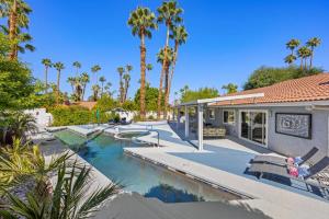 a house with a swimming pool with palm trees at Serenity Palms- Gorgeous Villa in Palm Springs in Palm Springs