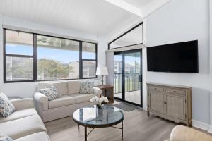 un soggiorno con divano e TV di Loggerhead 253- Beachfront Residence w Vaulted Ceilings a Sanibel