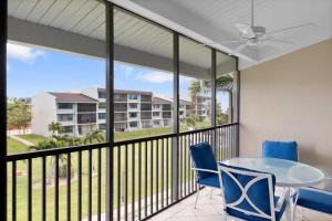 a room with a balcony with a table and chairs at Loggerhead 253- Beachfront Residence w Vaulted Ceilings in Sanibel