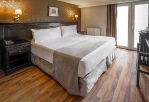 1 cama grande en un dormitorio con suelo de madera en Lennox Ushuaia en Ushuaia