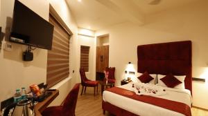 pokój hotelowy z łóżkiem i telewizorem z płaskim ekranem w obiekcie Hotel Elpaso w mieście Selam