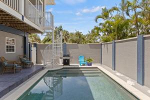 a swimming pool with chairs and a table next to a fence at Mango Margarita- Beach Home with Pool Sleeps 12 in Fort Myers Beach