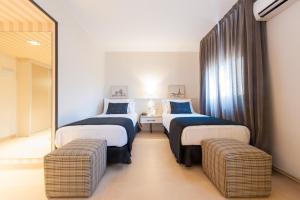 a hotel room with two beds and two chairs at New Hotel Colon in Mataró