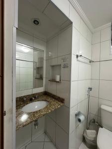 a bathroom with a sink and a mirror and a toilet at Hotel Modena - São José dos Campos in São José dos Campos
