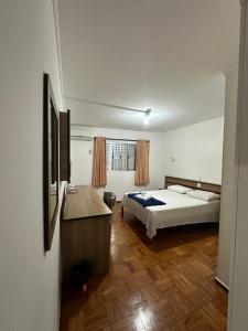 a bedroom with a bed and a desk in it at Hotel Modena - São José dos Campos in São José dos Campos