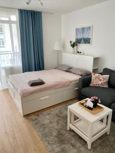 a bedroom with a bed and a couch and a table at Gemütliches Appartement nahe Universitätsklinik in Magdeburg
