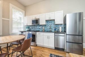 a kitchen with a table and a stainless steel refrigerator at Charming Condo in Historic Downtown Building in Wilmington