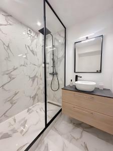 a bathroom with a sink and a shower with a mirror at La Kanal de Périgueux - Centre historique in Périgueux