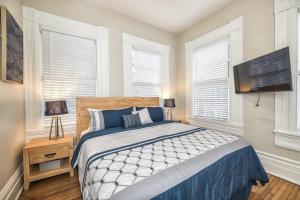 a bedroom with a bed and a flat screen tv at Charming Condo in Historic Downtown Building in Wilmington