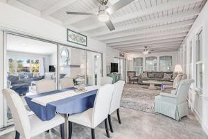 a dining room with a blue table and white chairs at Gorgeous Pool Home in Lake Murex Sanibel in Sanibel