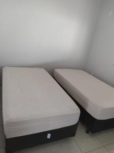 two beds sitting next to each other in a room at Casa primavera caldas novas in Caldas Novas
