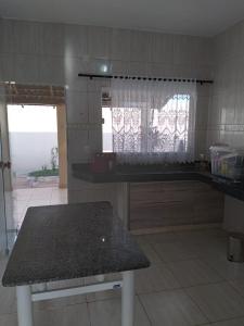 a kitchen with a counter and a table in it at Casa primavera caldas novas in Caldas Novas