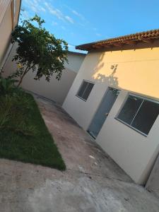 a driveway leading to a white house with a door at Casa primavera caldas novas in Caldas Novas